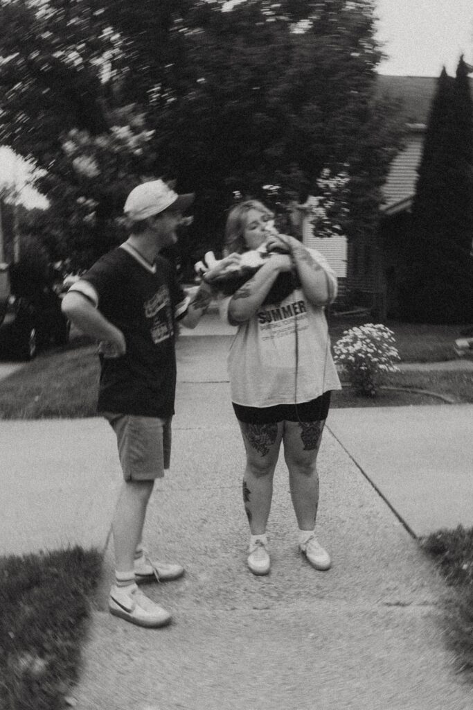 a couple on a walk with their dote on their cat who she holds