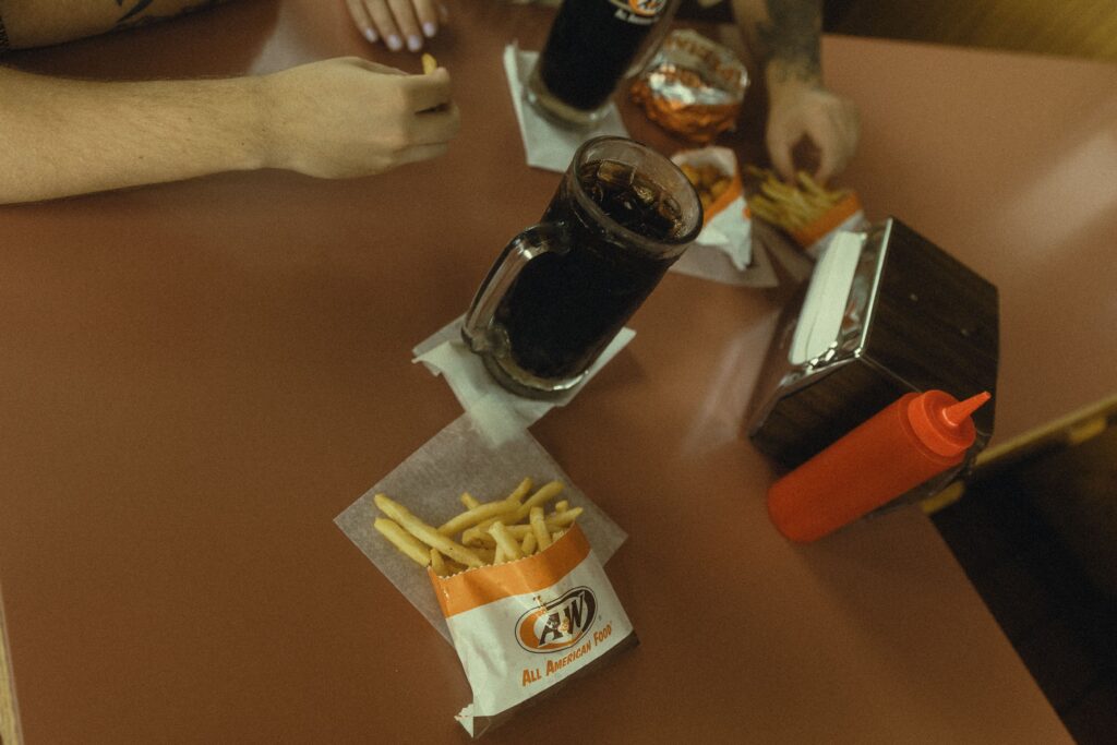 a couple share root beer and a meal at a&w during their couples photography