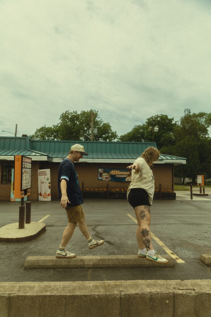 a couple balance on a parking barrier during their couples photography session