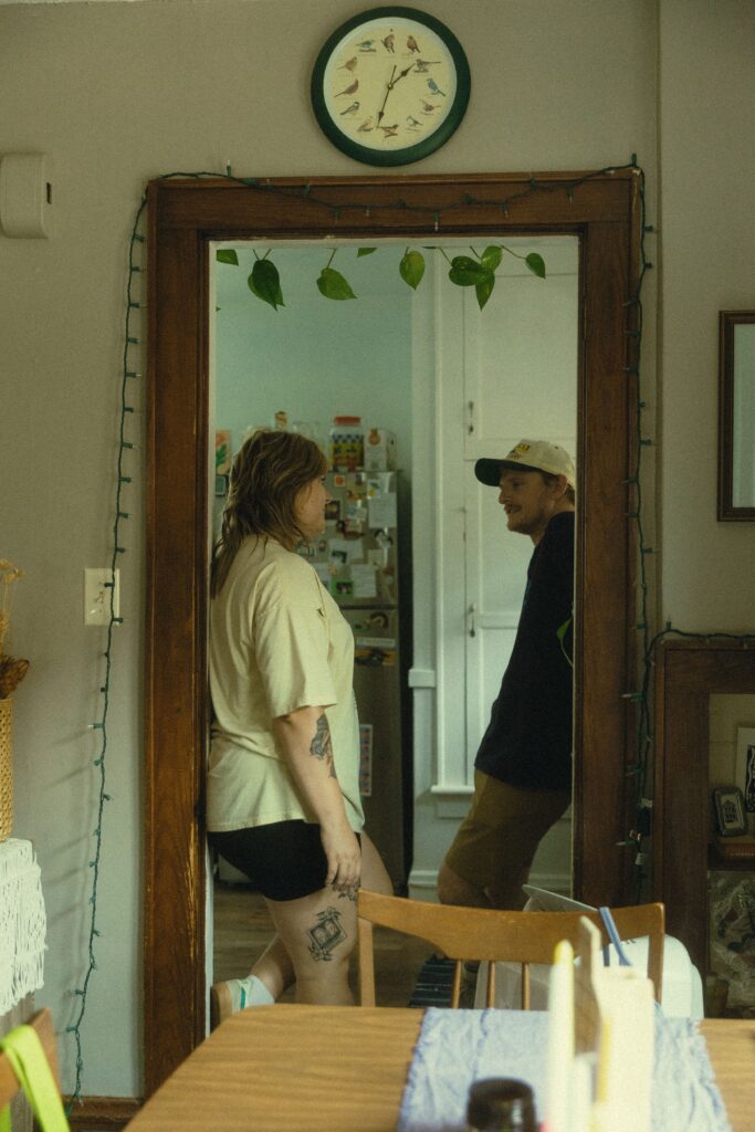 a couple look at each other from opposite sides of a doorframe during their couples photography