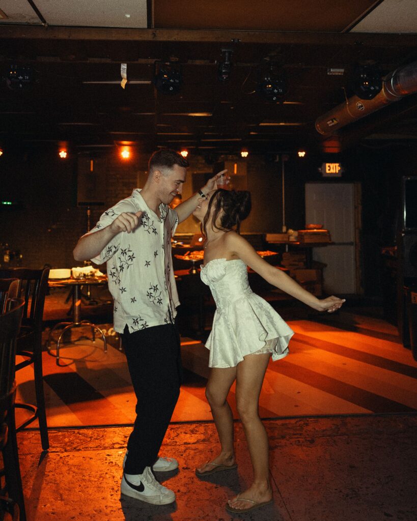 a couple in casual wedding attire dance together