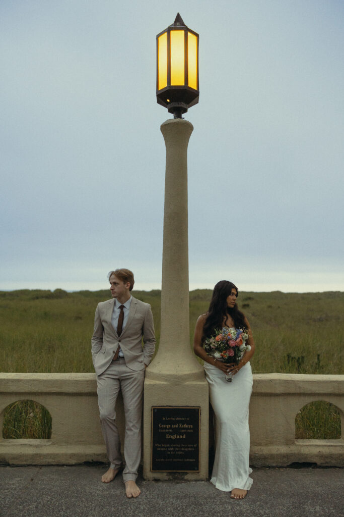 an eloping couple stand on opposite sides of a lamppost and face opposite directions