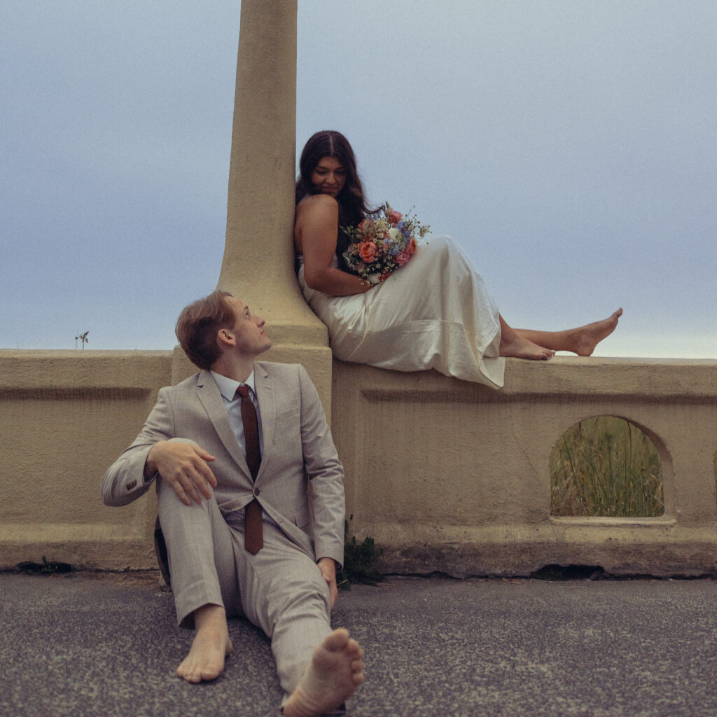 a couple sit facing opposite directions and smile at each other