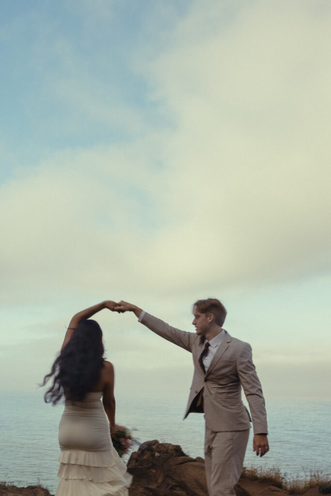 a couple dances in front of the ocean