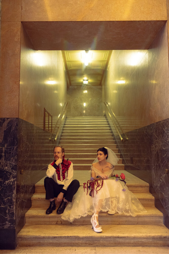Newlyweds are photographed on the staircase following their courthosue elopement in MI