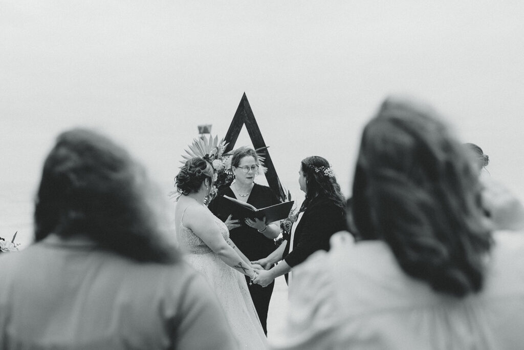 A black and white image of a MI couple exchanging vows as they elope in Michigan