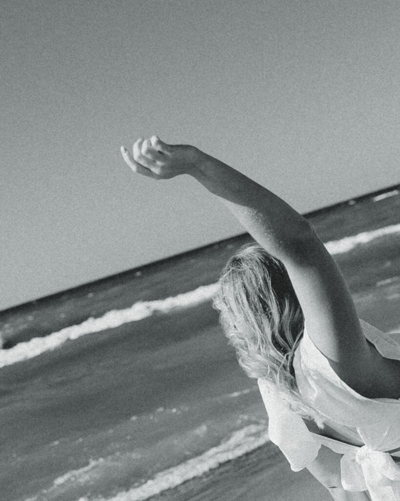 A bride celebrates her Michigan elopement on the shore of a beach