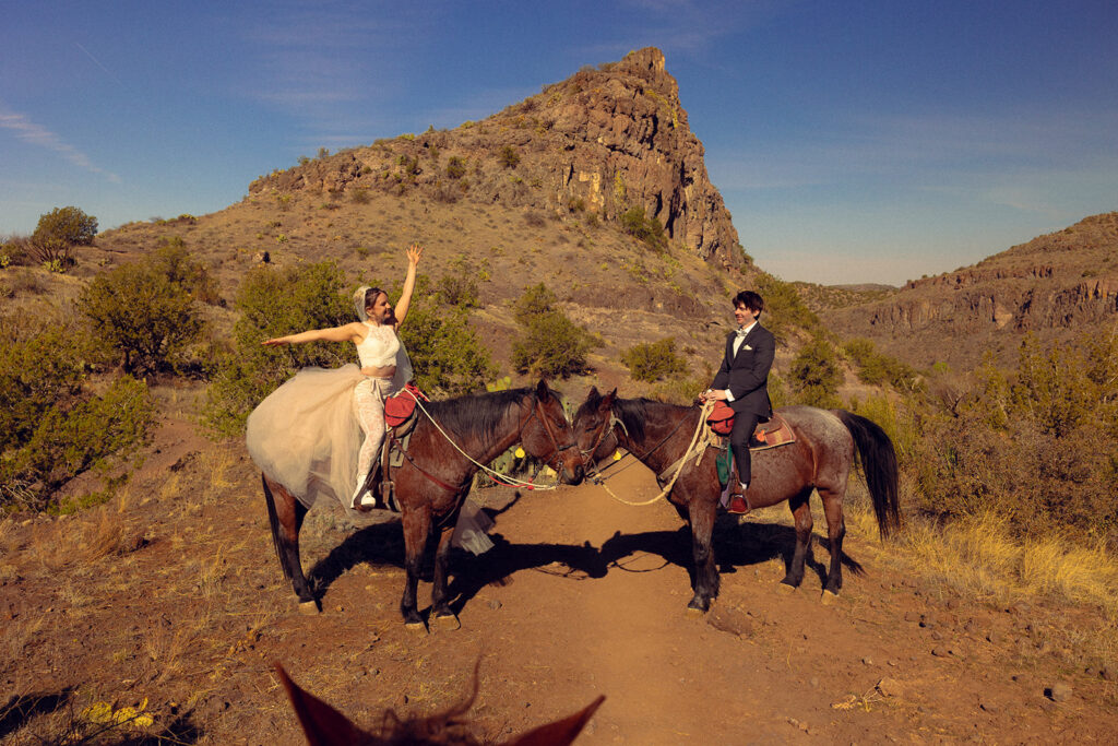 A couple rides horseback in their wedding attire while eloping in MI