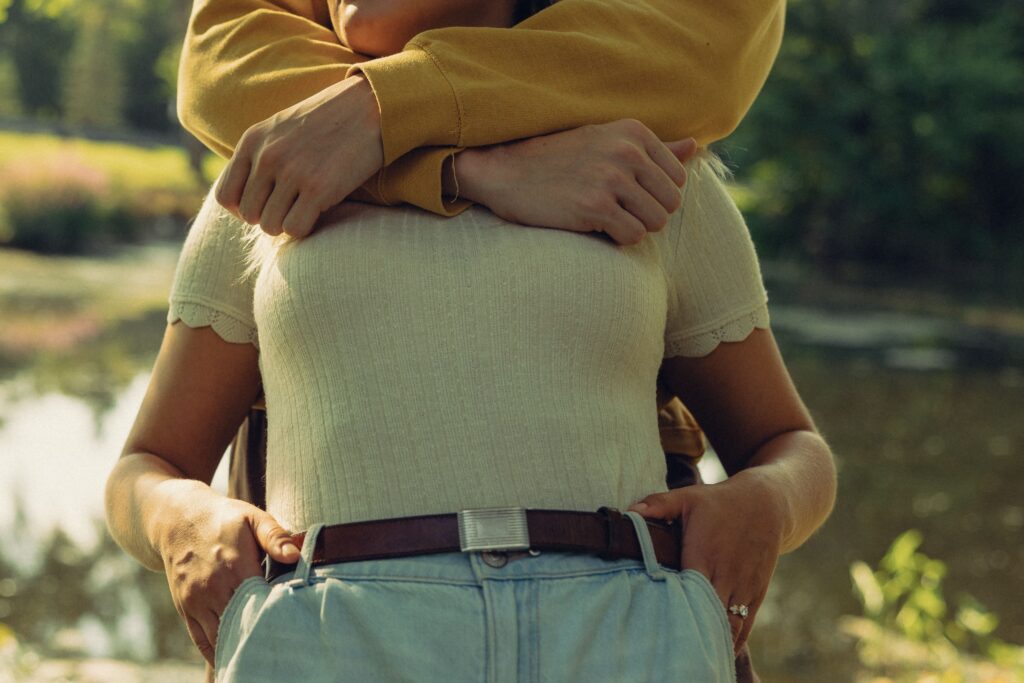 engagement photographer photo of a couple leaning against each other, his arms around her neck