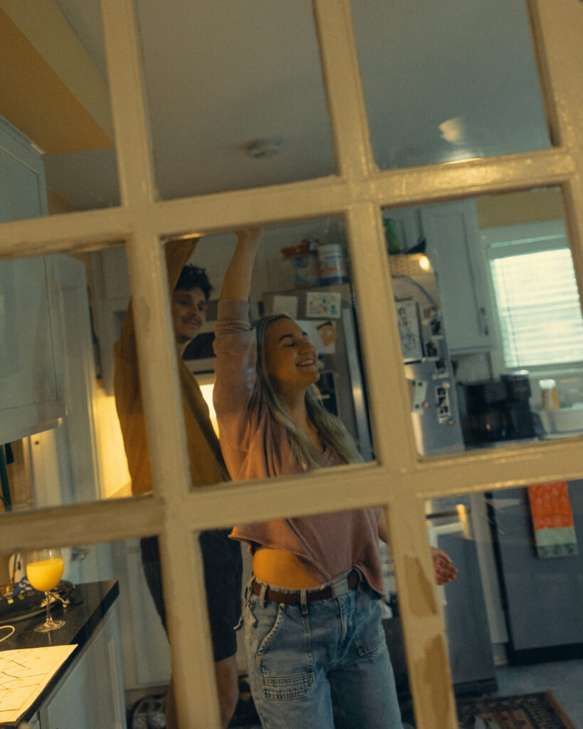 an engaged couple dance in the kitchen during their at home engagement photos grand rapids