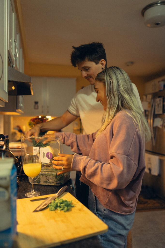 an engaged couple make breakfast together