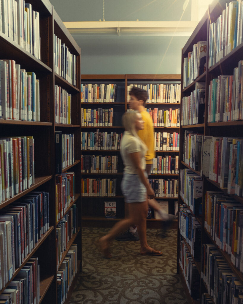 a motion blur portrait of a couple walking through a library for their engagement photos grand rapids