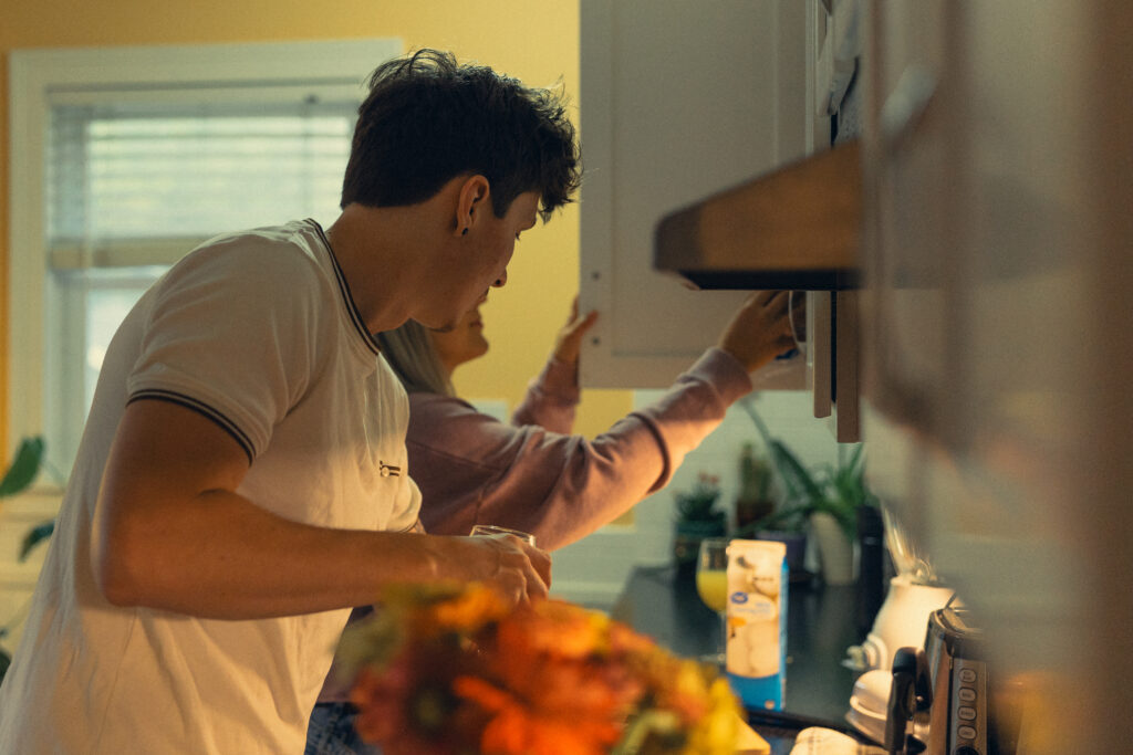 an engaged couple use the kitchen while cooking breakfast for engagement photos grand rapids