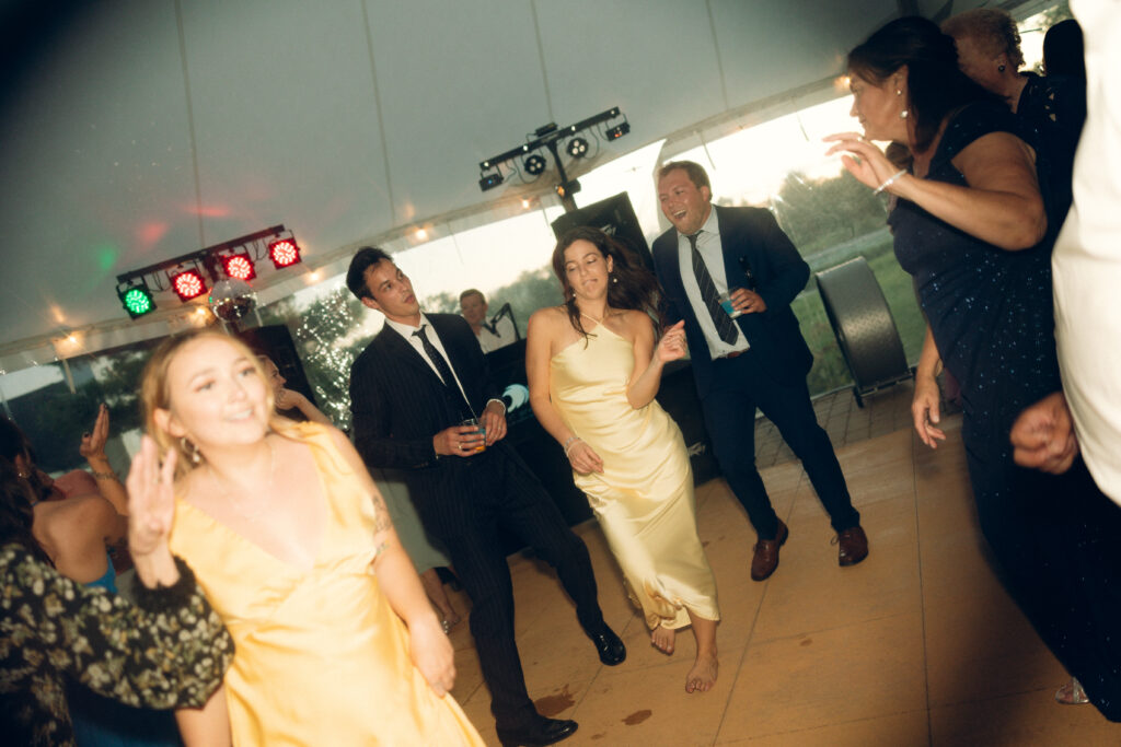 documentary style wedding photos, a group of guests dance together towards the end of the night