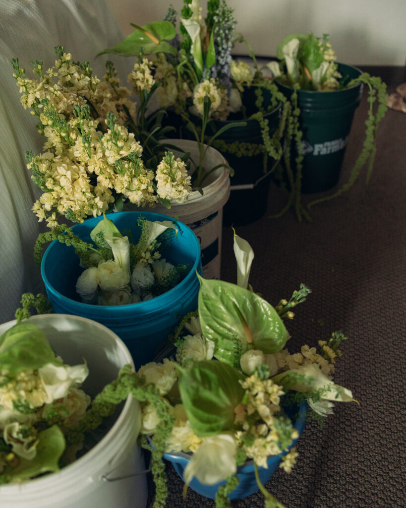 documentary style wedding photos flowers wait in buckets of water before the bride puts them together into bouquets