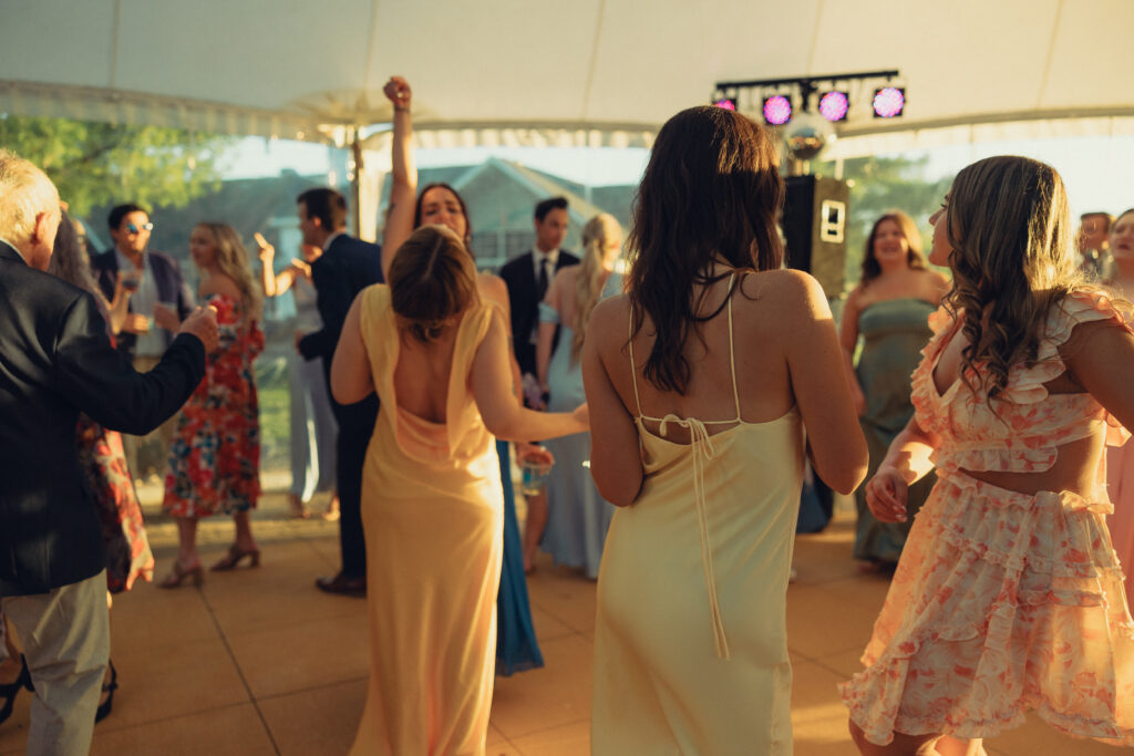 a group of wedding goers dance together on the dance floor