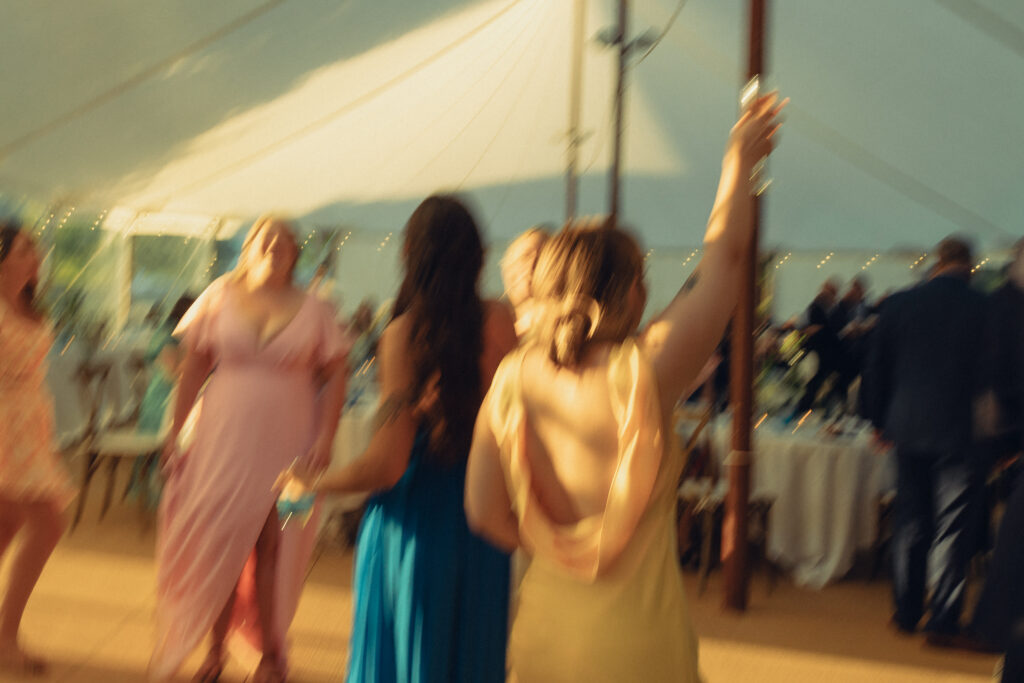 a motion blur documentary style wedding photo of bridesmaids dancing