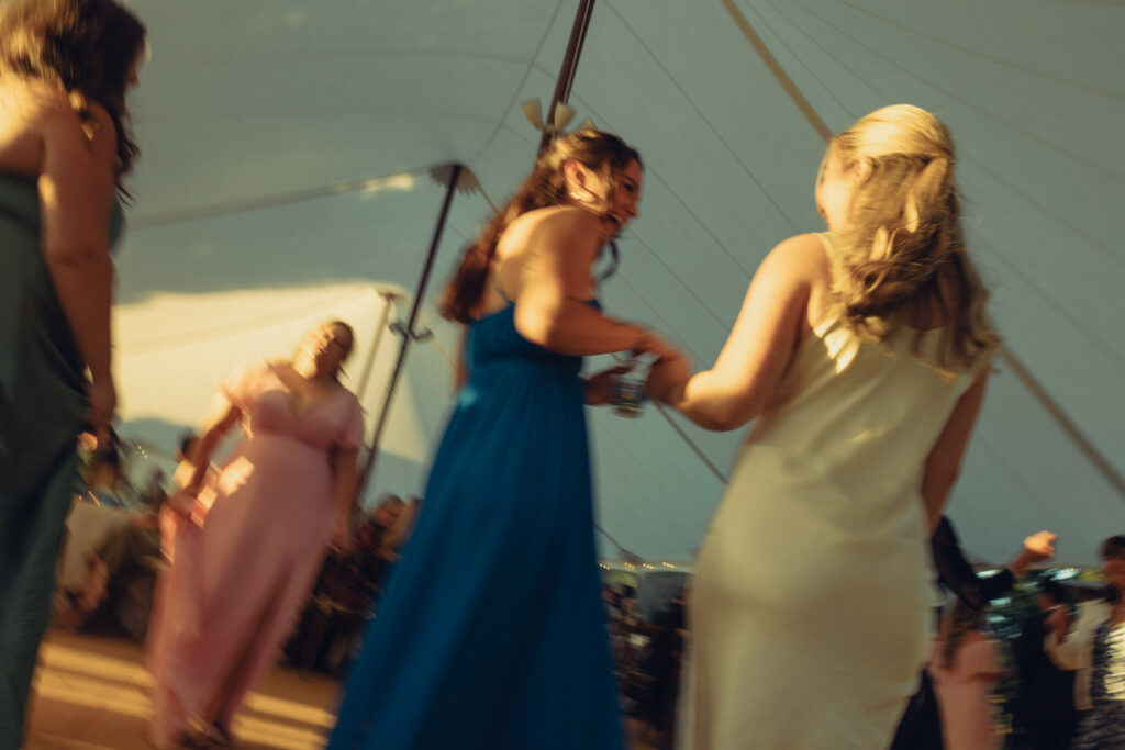 a bride stands on the dance floor with her bridesmaids in this motion blur documentary style wedding photo