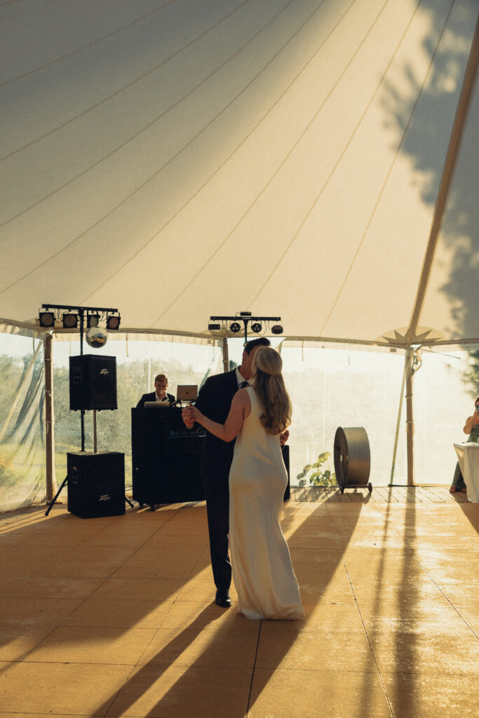 documentary style wedding photos, the bride and groom share their first dance with shadows dancing around them