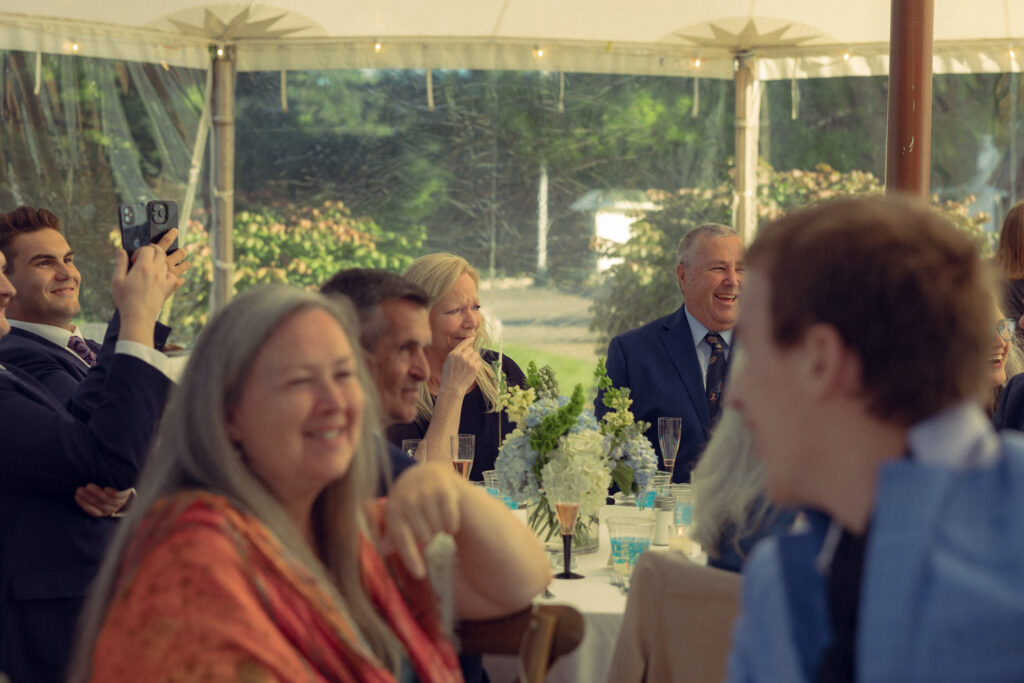 wedding guests laugh and show heartfelt emotion during a wedding reception with documentary style wedding photos