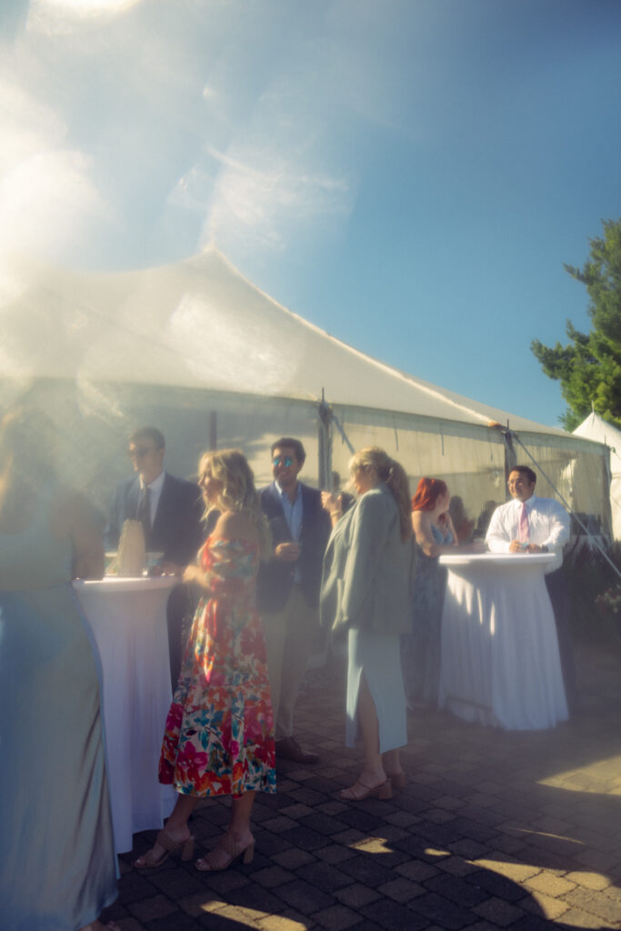 guests wait in line at a wedding reception next to the tent