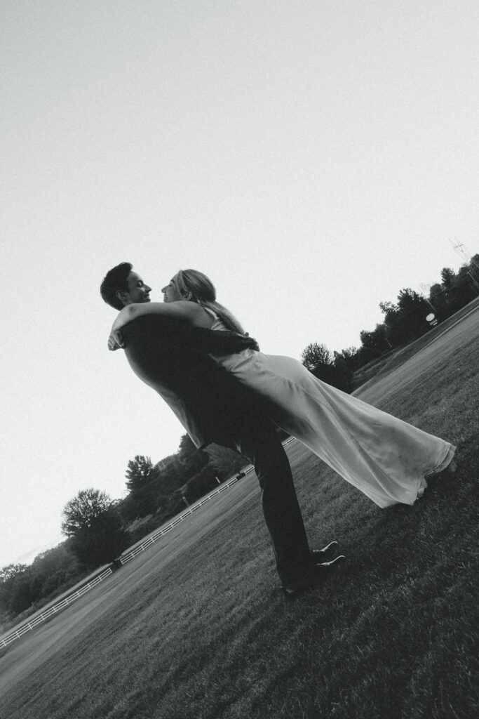 the bride leans on the groom with her arms around his shoulders as he holds her at her waist during their documentary wedding photos