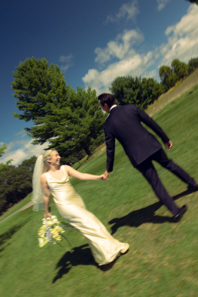 the bride and groom hold hands laughing in this motion blur documentary style wedding photo