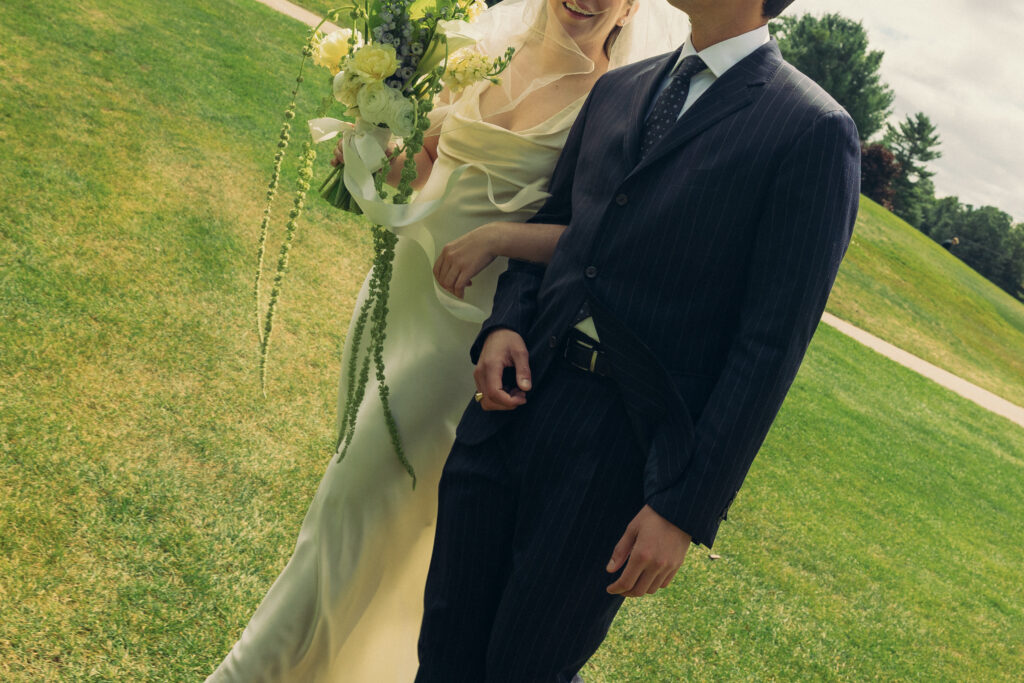 newlyweds smile and walk arm and arm 