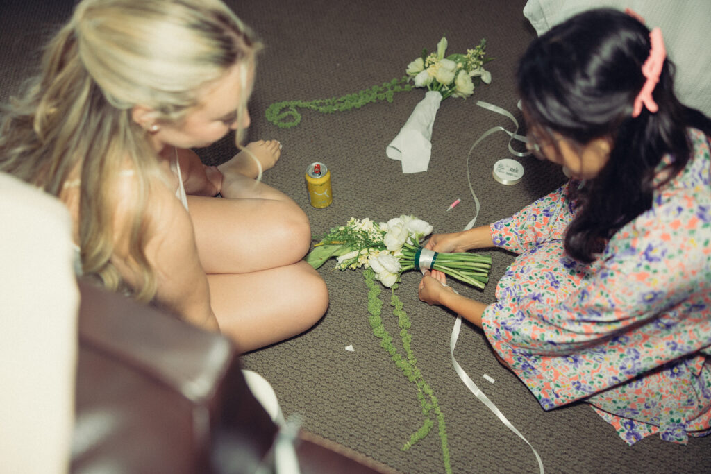 the bride and a bridesmaid put together bouquets for the ceremony