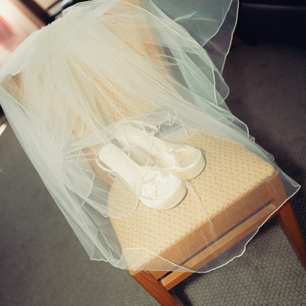 documentary style wedding photos the bride's veil is draped over a chair with her shoes underneath