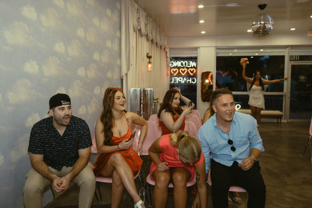 friends of the bride and groom react to their surprise wedding during their wedding photos in vegas