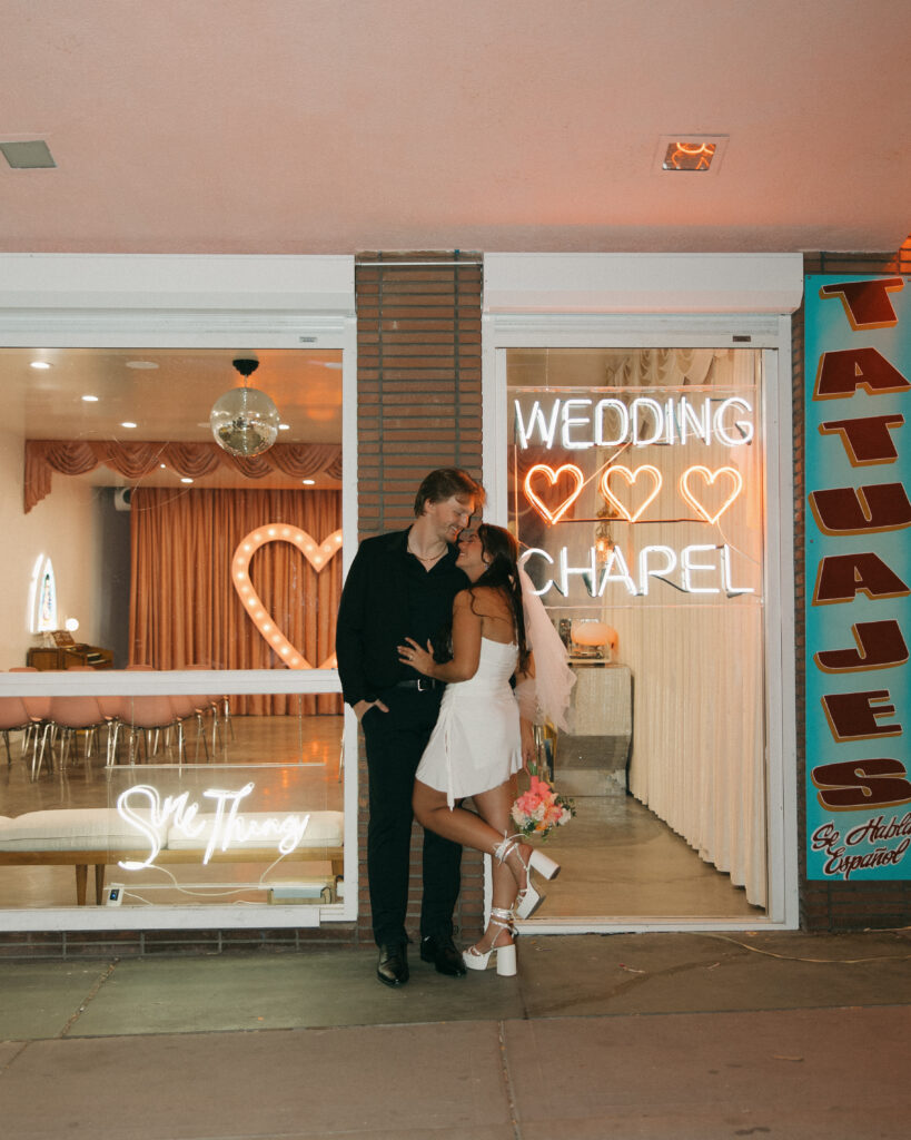 a couple stands together outside of a vegas wedding chapel during their wedding photos in vegas