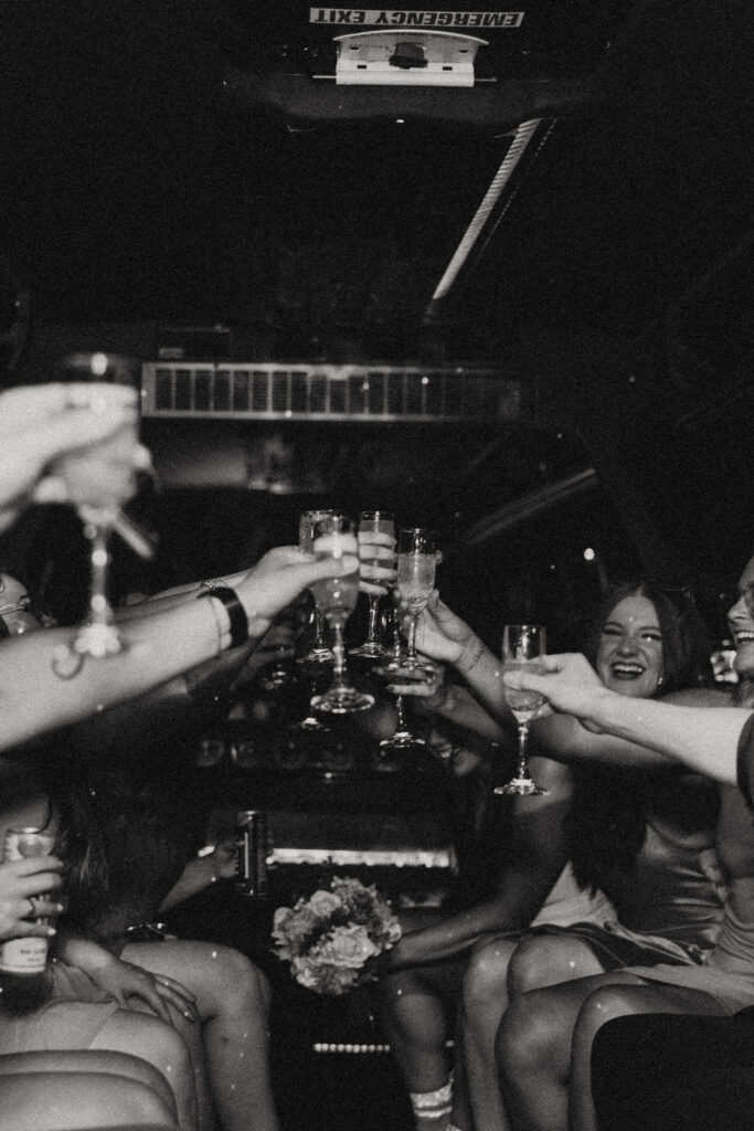 a group of people raise their glasses to toast while smiling and riding a party bus