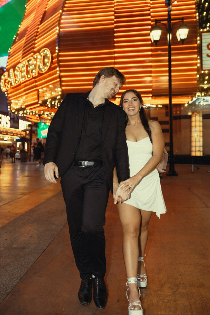 newlyweds walk on the street in front of a vegas casino during their vegas elopement photography