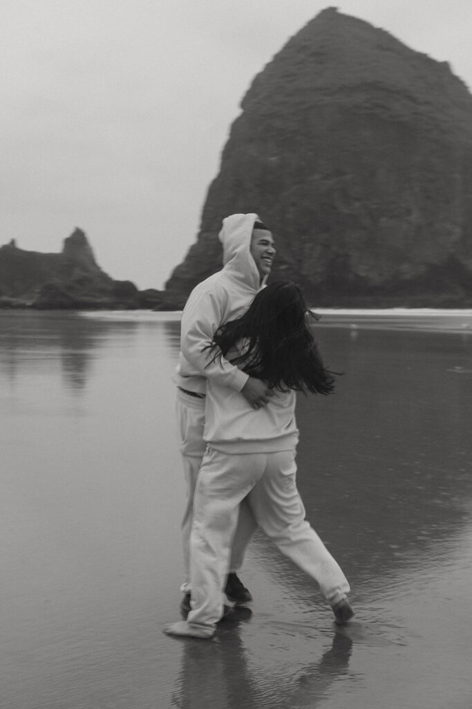 a black and white motion blur portrait of a could hugging on an oregon beach during their elopement photoshoot