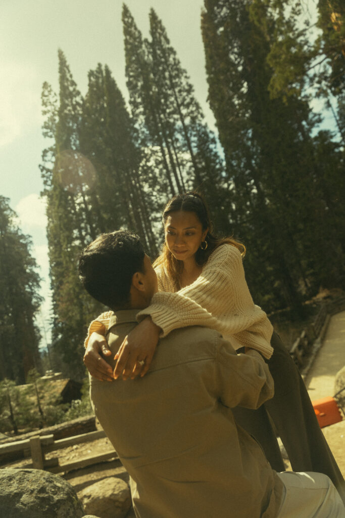 sequoia national park engagement photos were a woman rests her hands on her fiancee's shoulders as they look into each others eyes