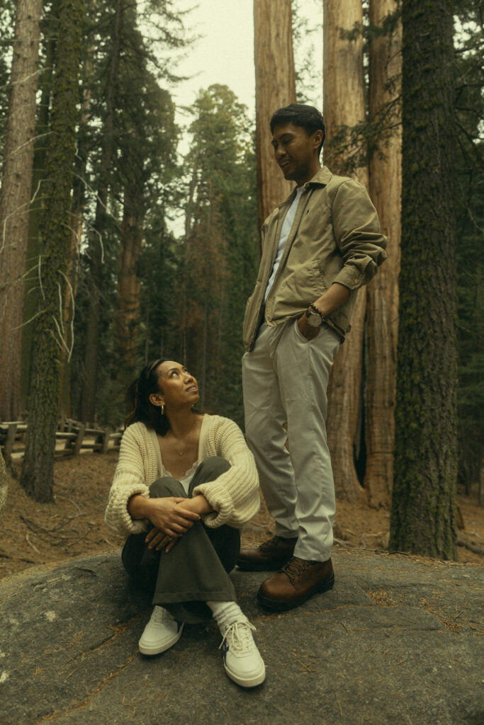 a woman sits and looks up at her fiancee who stands next to her