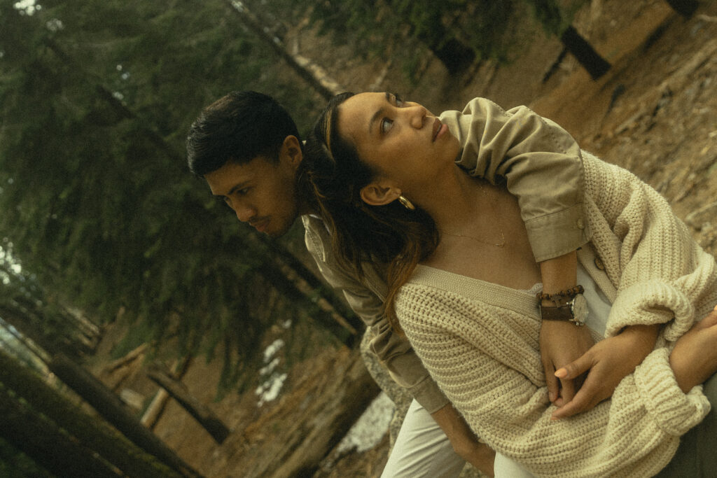sequoia national park engagement photos where the couple sits together, his arm around her as they look in different directions