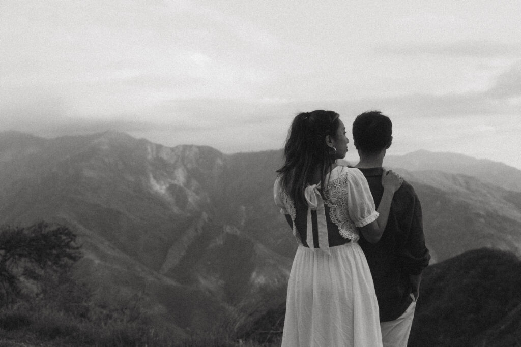 a black and white portrait of a couple standing in front of a mountain view during their sequoia national park engagement photos