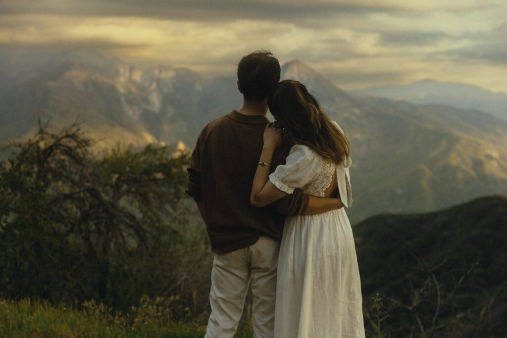 sequoia national park engagement photos where the couple shares an embrace while looking out at the mountains