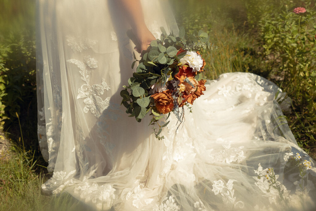 A closeup of a bridal bouquet against a lace dress taken by grand rapids wedding photographer Anika B Photography