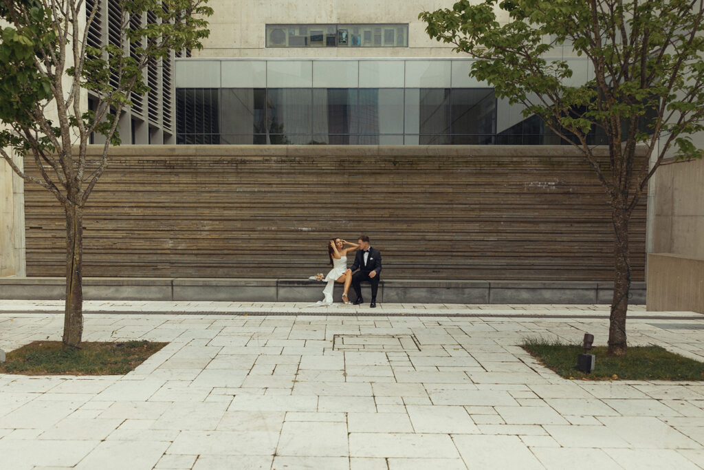 Newlyweds are pictured seated outside of the GRAM, one of many unique wedding venues in grand rapids michigan