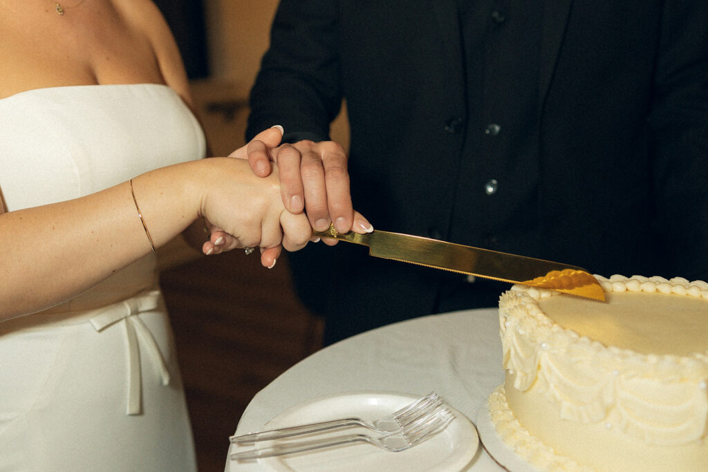 A Michigan newlywed couple cuts the cake at their hotel wedding venues grand rapids