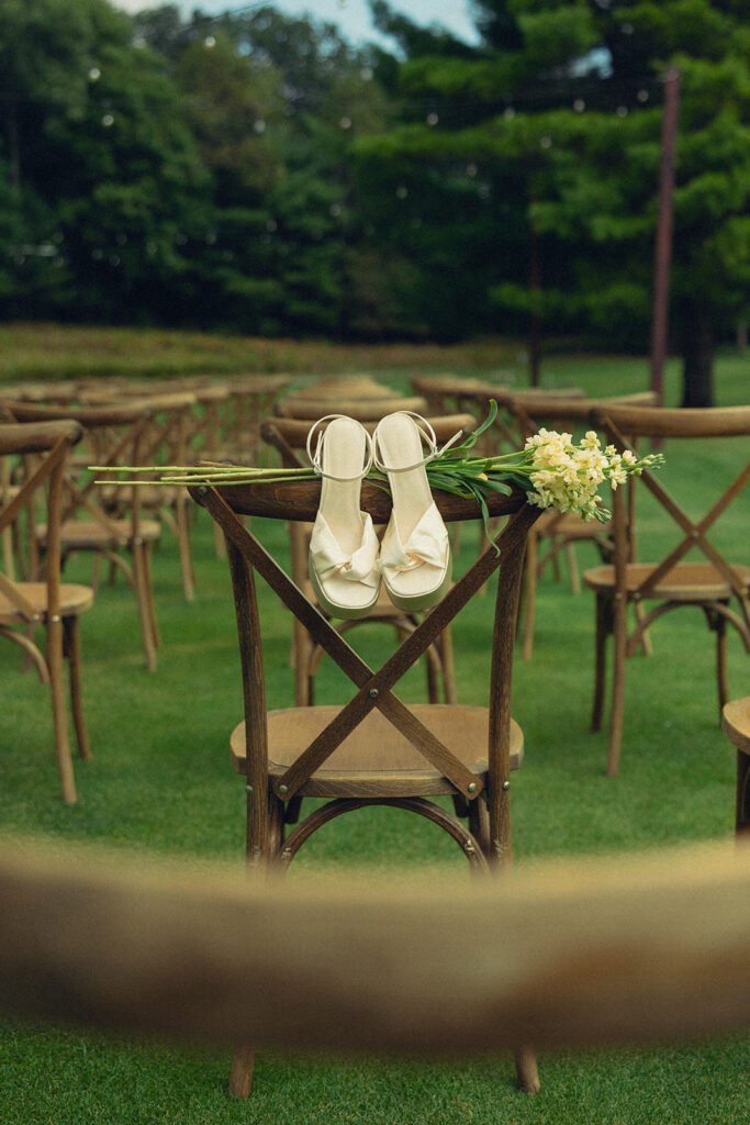 Bridal shoes are draped on the chair at an outdoor wedding venues grand rapids MI