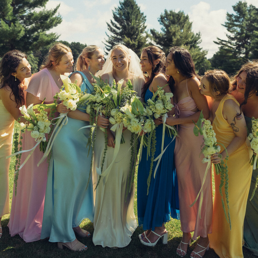 Bridesmaids wearing dresses of all color surround a Michigan bride as part of a guide to wedding venues in grand rapids