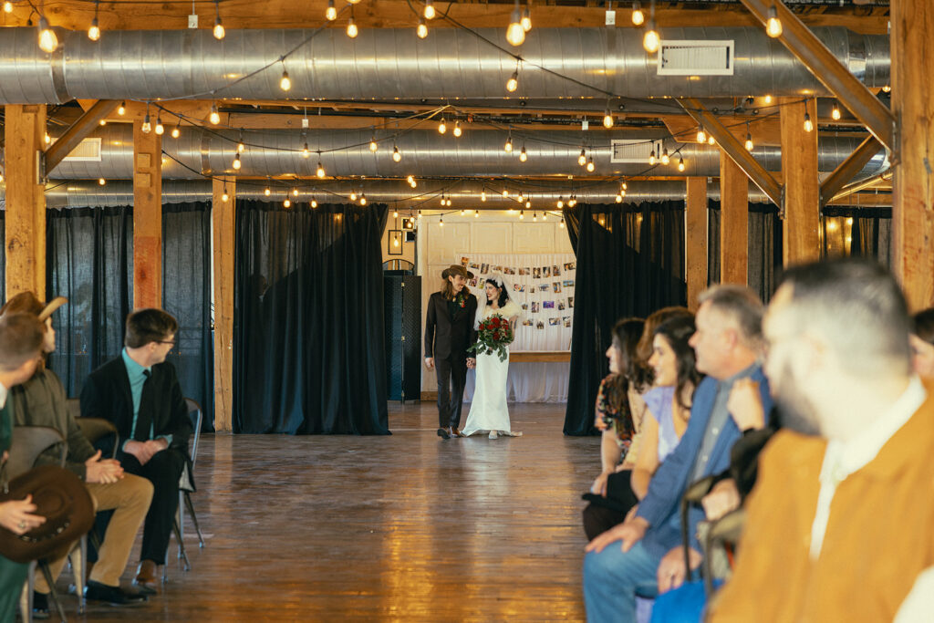 Wedding guests turn to look at the bride and groom as they make their way down the aisle at their Battle Creek wedding in Southwest MI 