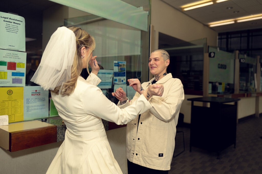 A Michigan couple wearing their wedding attire stand at the Kent County clerk's window befor their Grand Rapids courthouse wedding 