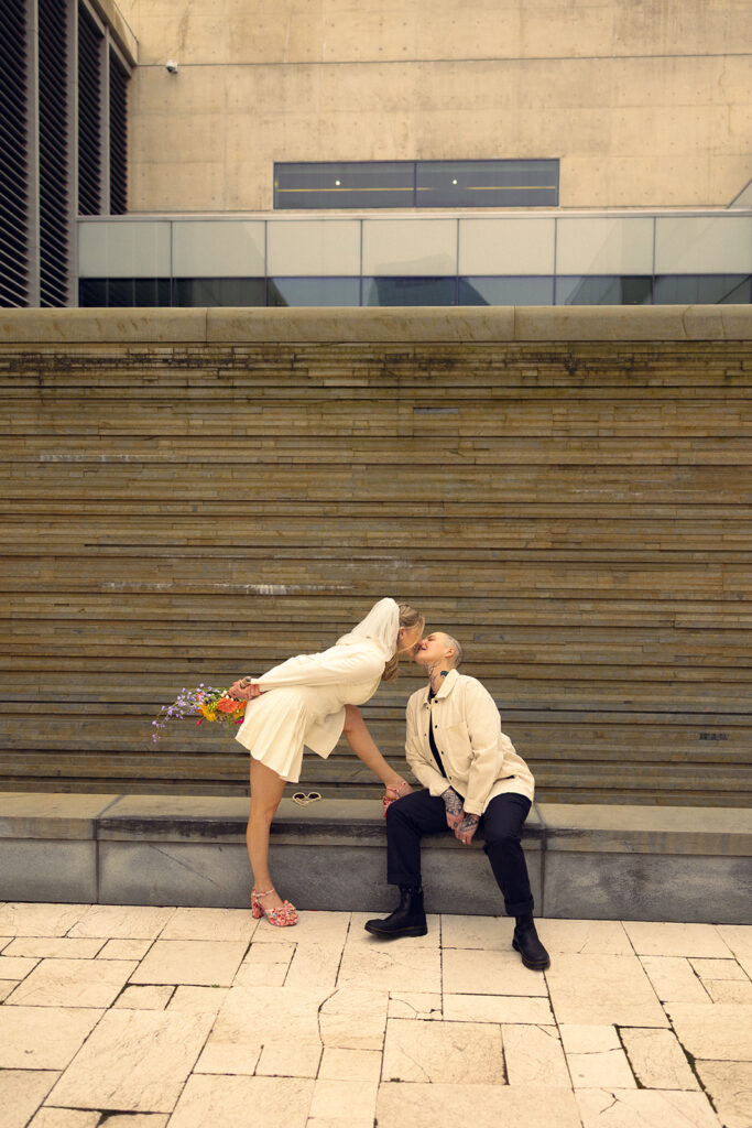 A Michigan  couple share a kiss outside GRAM during bridal portraits with Michigan elopement photographer, Anika B Photography