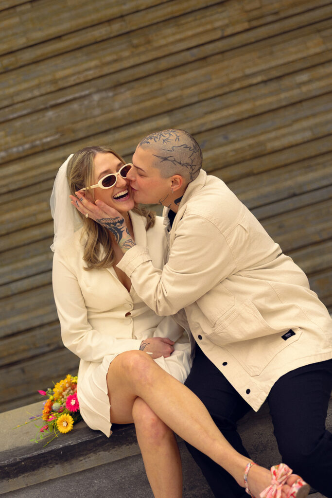 Newlyweds share a kiss on a bench outside GRAM before their courthouse wedding grand rapids mi