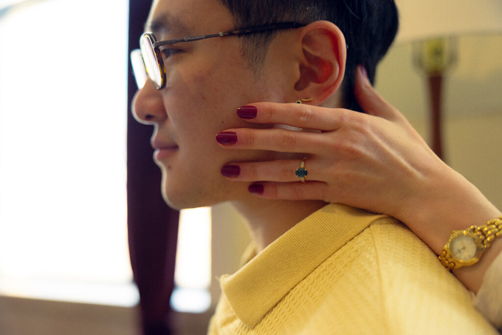 An image from a Michigan engagement session of an emerald solitaire engagement ring and a close up of the groom-to-be's side profile 